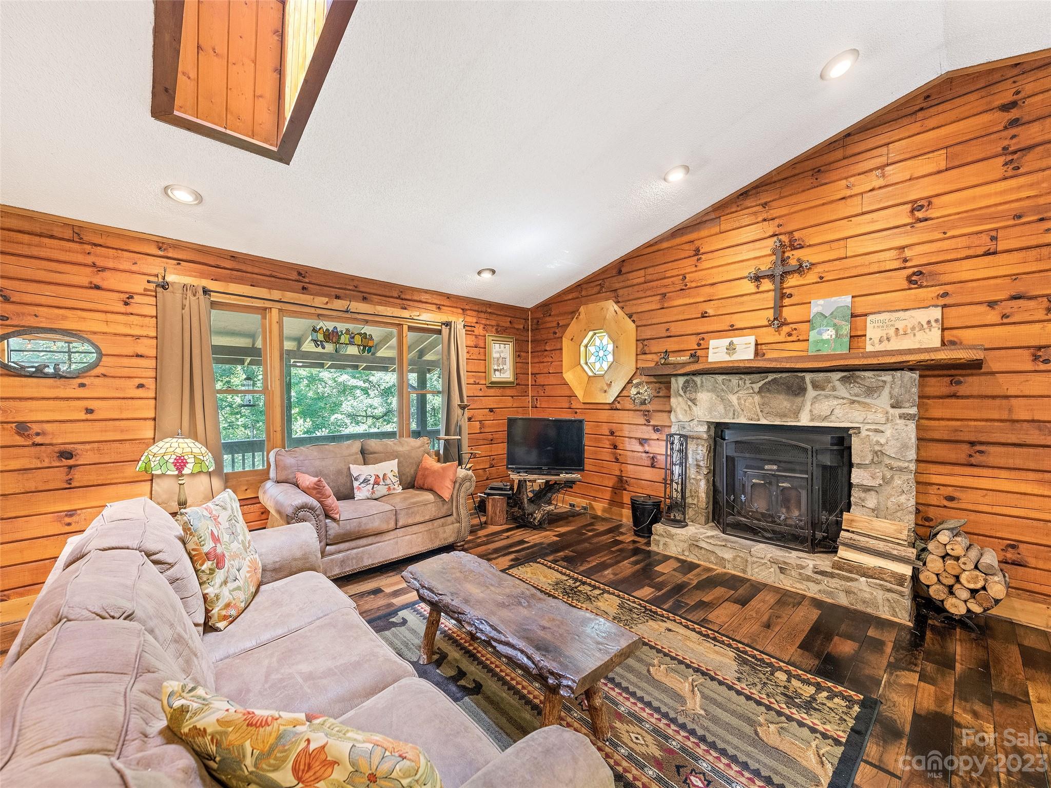 28 Honeybear Lane Clyde, NC 28721 - Photo 10 of 43 a living room with furniture a fireplace and a large window