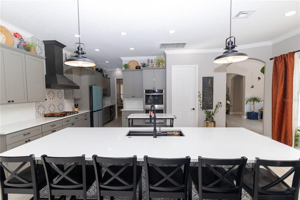 3305 Schoolhouse Road St. Cloud, FL 34773 - Photo 10 of 83 a dining room with stainless steel appliances kitchen island a table and chairs