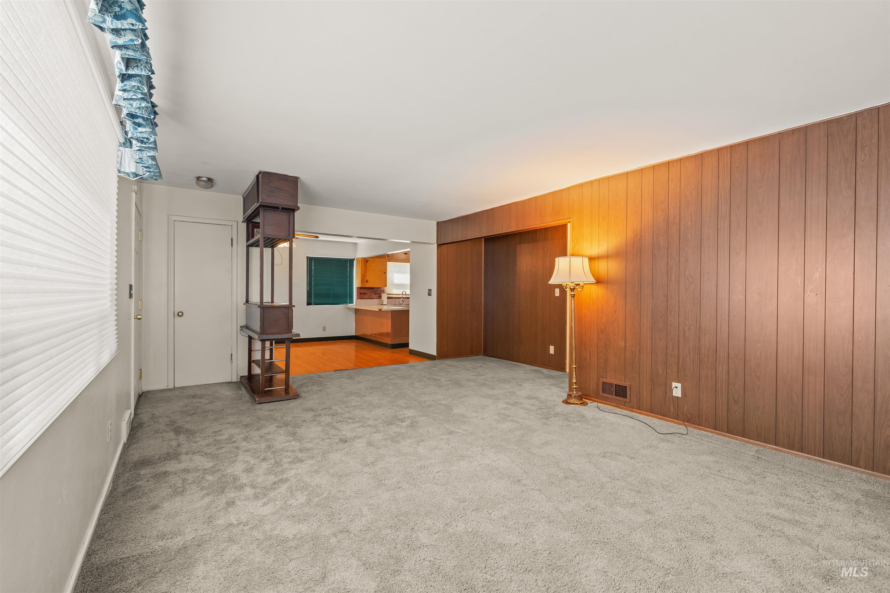 1663 9th Avenue Lewiston, ID 83501 - Photo 34 of 36 Expansive carpeted room featuring vertical wood paneling and a large window with horizontal blinds