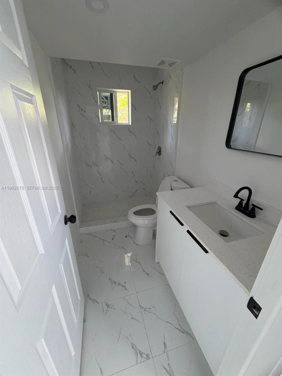 10020 Southwest 171st Street Miami, FL 33157 - Photo 13 of 18 a bathroom with a sink a toilet and a mirror