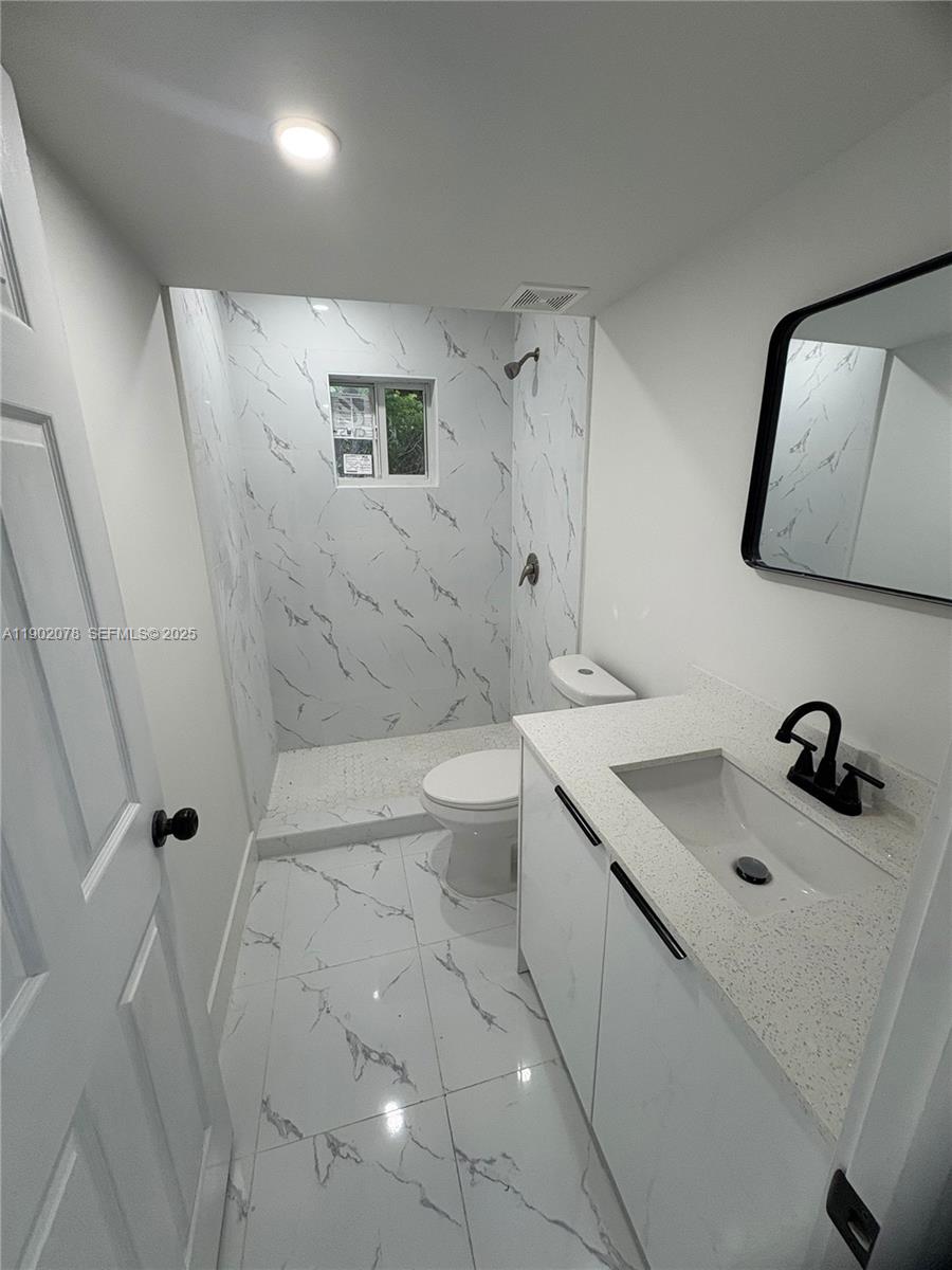 10020 Southwest 171st Street Miami, FL 33157 - Photo 14 of 18 a bathroom with a sink a toilet and mirror