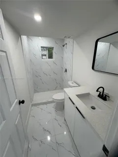 a bathroom with a sink a toilet and mirror