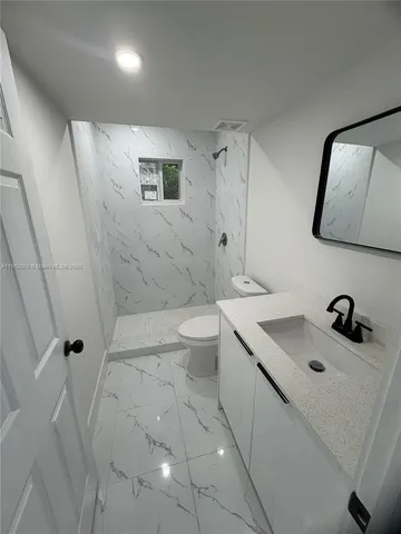 a bathroom with a sink a toilet and mirror