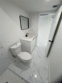 a white toilet sitting next to a bathroom sink