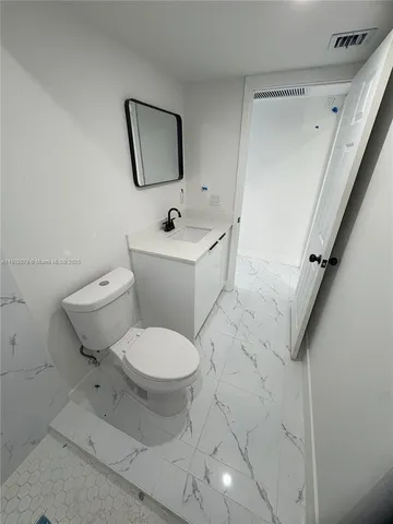 a white toilet sitting next to a bathroom sink