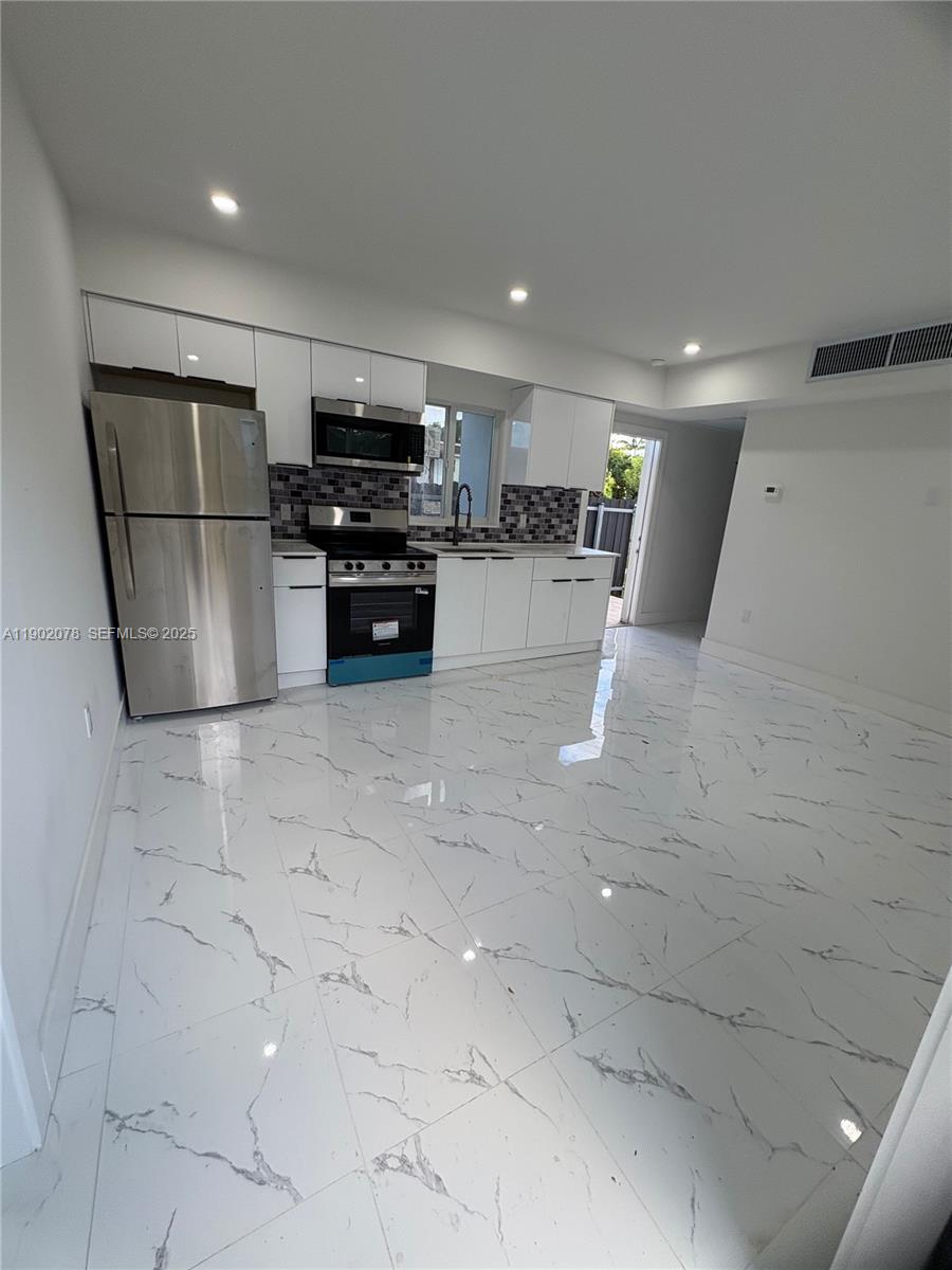 10020 Southwest 171st Street Miami, FL 33157 - Photo 3 of 18 a kitchen with stainless steel appliances a refrigerator and a stove top oven