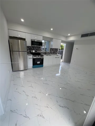 a kitchen with stainless steel appliances a refrigerator and a stove top oven