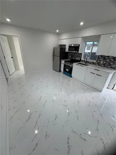 a large white kitchen with stainless steel appliances