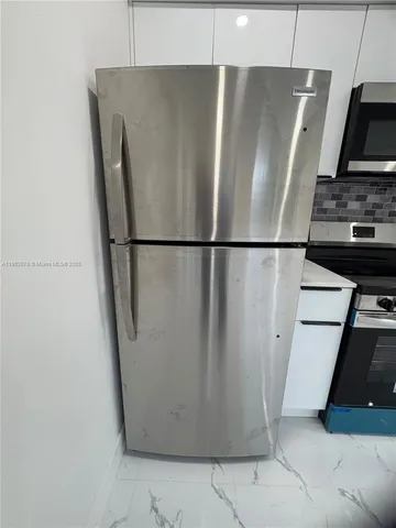 a white refrigerator freezer and a stove sitting inside of a kitchen