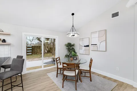 a dining room with furniture window and wooden floor