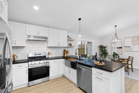 a kitchen with granite countertop a sink stainless steel appliances and cabinets