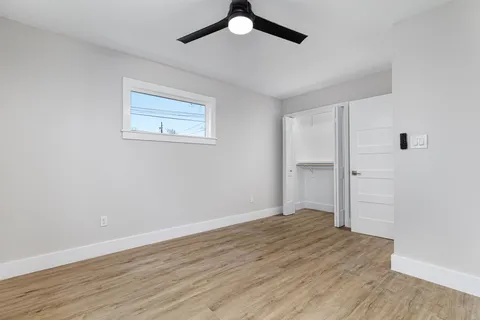 a view of empty room with wooden floor