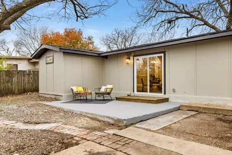 a front view of a house with garden and sitting area