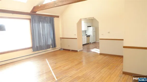 a view of a room with wooden floor and a large window