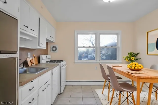 a kitchen that has a table chair and wooden cabinets