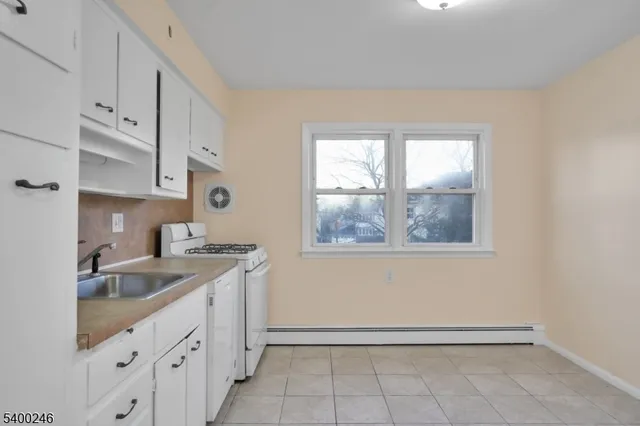 a kitchen with granite countertop white cabinets and window