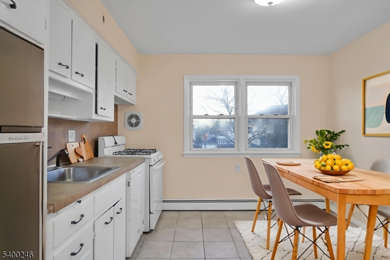 726 Gates Terrace, Unit 2 Union, NJ 07083 - Photo 2 of 25 a kitchen that has a table chair and wooden cabinets