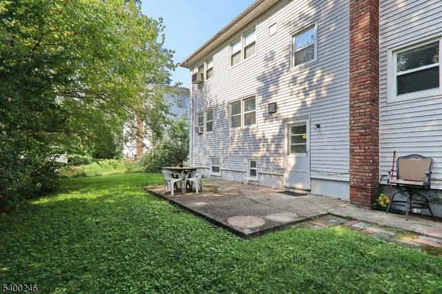 a view of backyard with chairs and table in patio