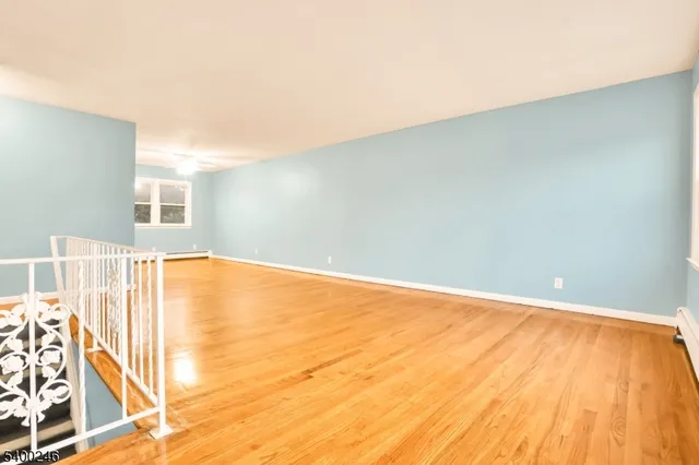 a view of a room with wooden floor and white walls