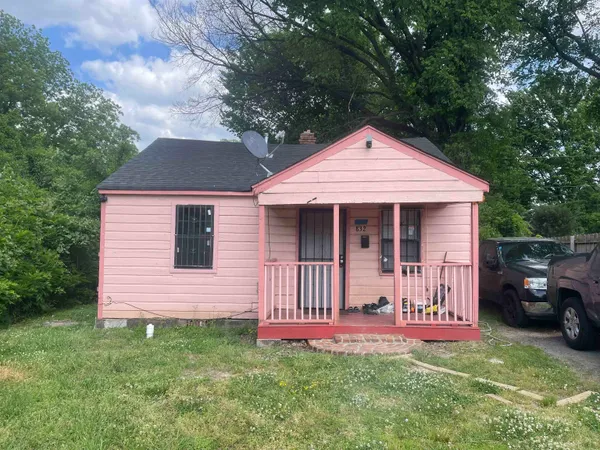 a front view of a house with a garden and yard