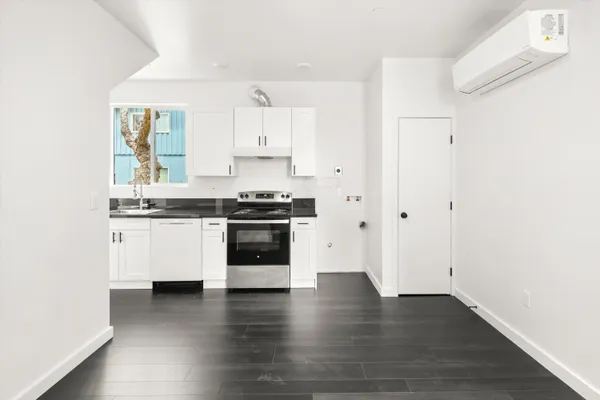 a kitchen with wooden floors and white stainless steel appliances