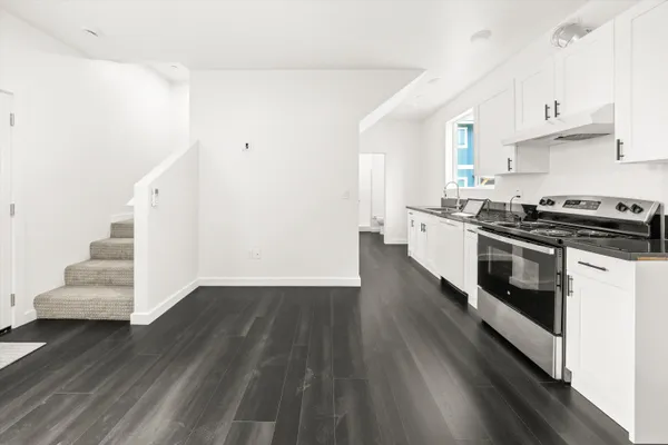 a kitchen with granite countertop a stove and a wooden floors