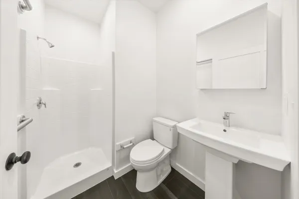 a bathroom with a sink a toilet and shower