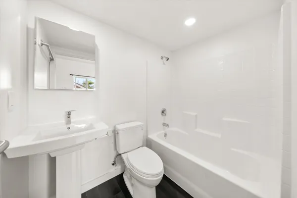 a white toilet sitting next to a bathroom sink