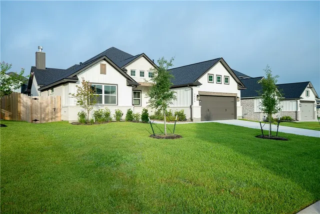 a view of a house with a yard and a garden