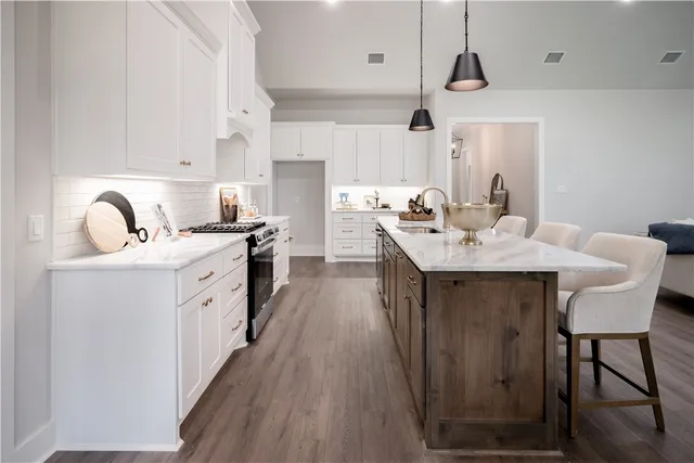 a living room with furniture kitchen view and a wooden floor