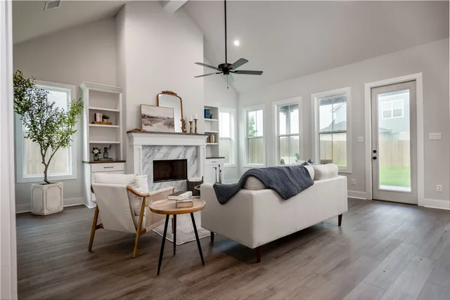 a living room with furniture a fireplace and a floor to ceiling window