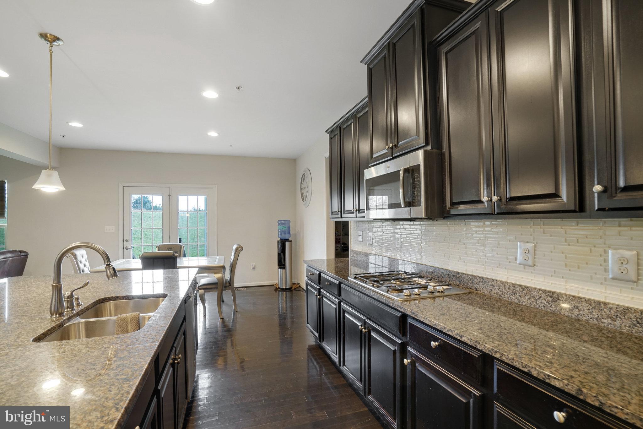 14333 Owings Avenue Brandywine, MD 20613 - Photo 9 of 16 a kitchen with granite countertop stainless steel appliances a sink stove and cabinets