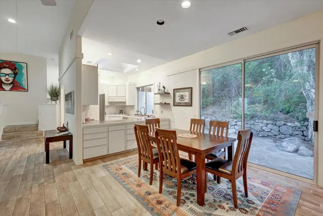 a dining room with furniture a rug and a floor to ceiling window