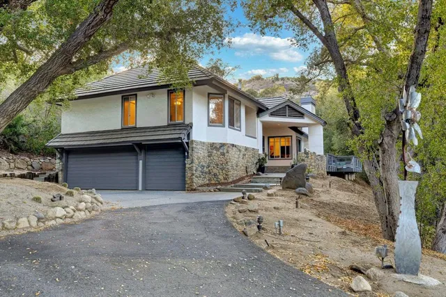 a front view of a house with a tree