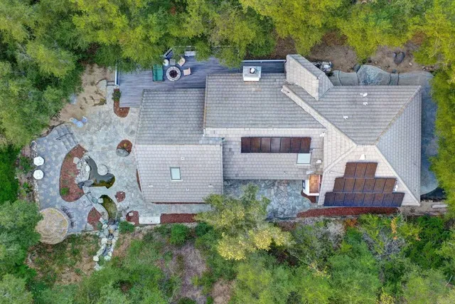 an aerial view of a pool yard and mountain view in back