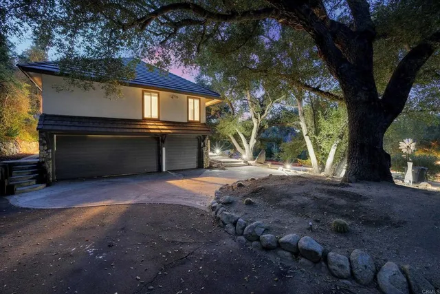 a view of a house with a tree in the forest