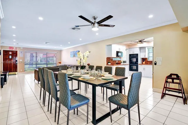 a dining room with stainless steel appliances kitchen island a table and chairs
