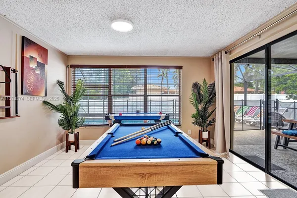 a room with pool table and windows