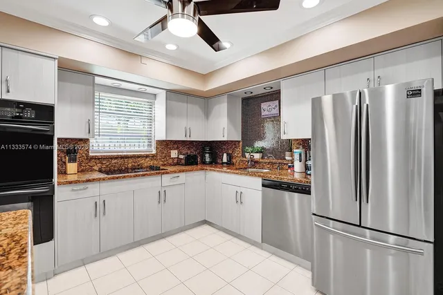 a kitchen with granite countertop stainless steel appliances a refrigerator sink and microwave