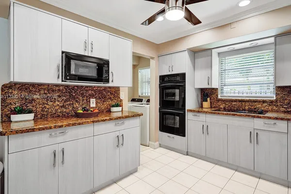 a kitchen with stainless steel appliances granite countertop a stove a sink and a microwave