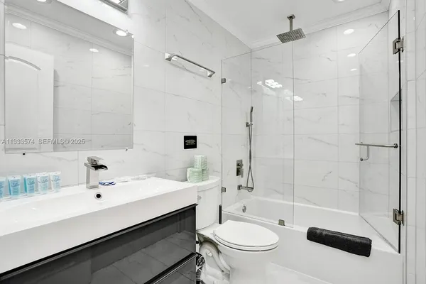 a bathroom with a sink a toilet a mirror and shower