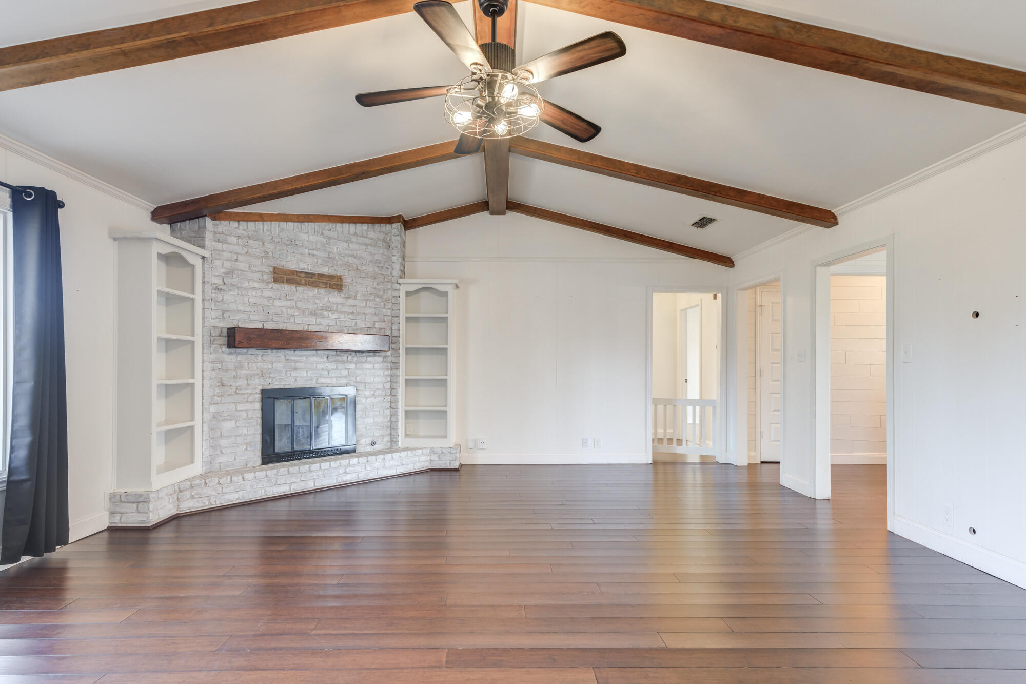 5604 70th Street Lubbock, TX 79424 - Photo 3 of 49 a view of an empty room with wooden floor fireplace and a window
