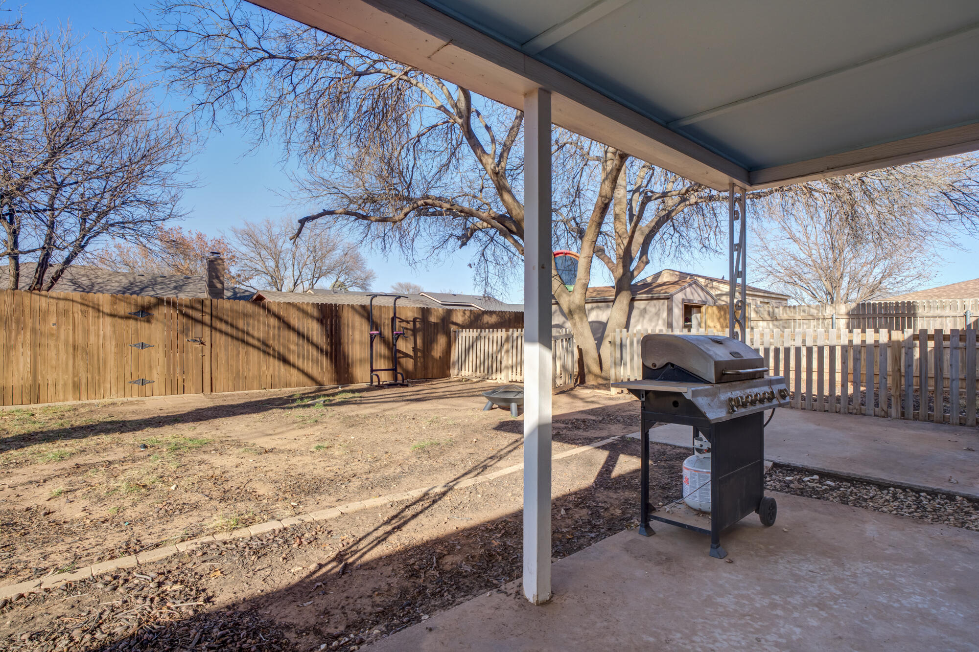 5604 70th Street Lubbock, TX 79424 - Photo 44 of 49 a view of a patio with a table chairs and wooden fence