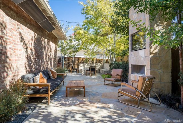 a backyard of a house with barbeque oven table and chairs