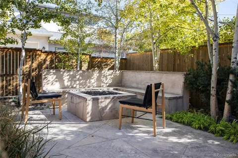 a view of backyard with table and chairs and a large tree