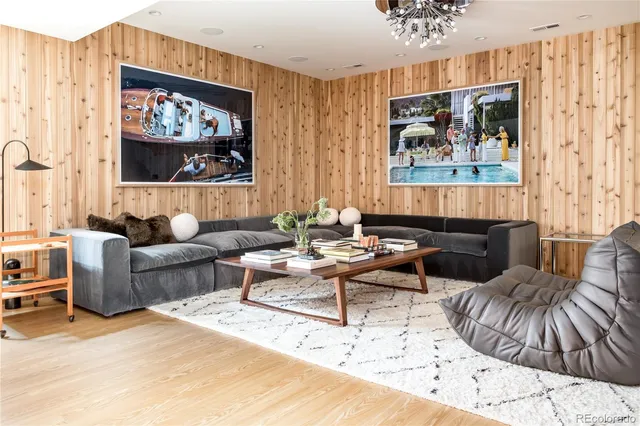 a living room with furniture and a painting on the wall