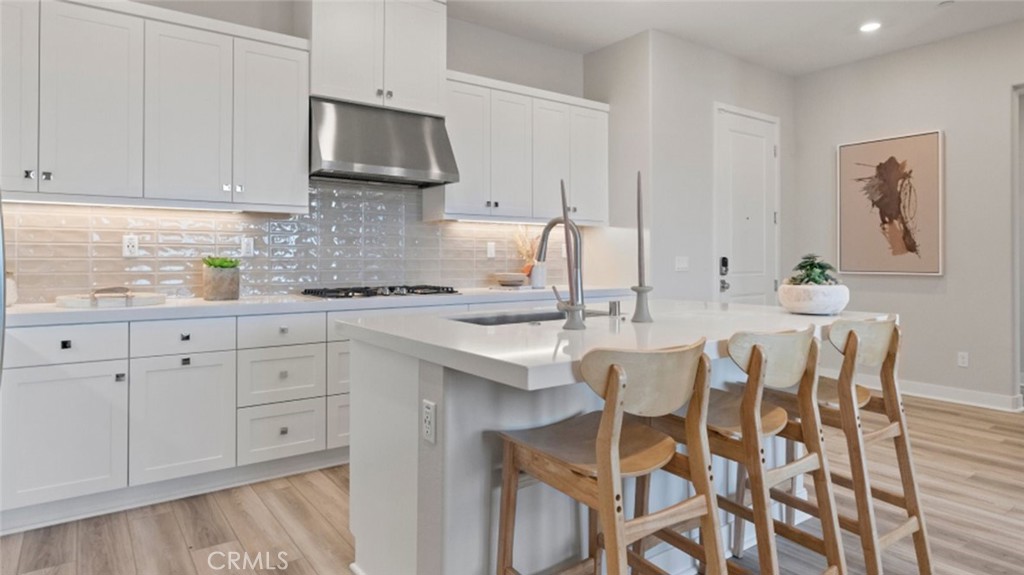 a kitchen with stainless steel appliances granite countertop a white cabinets and a stove top oven