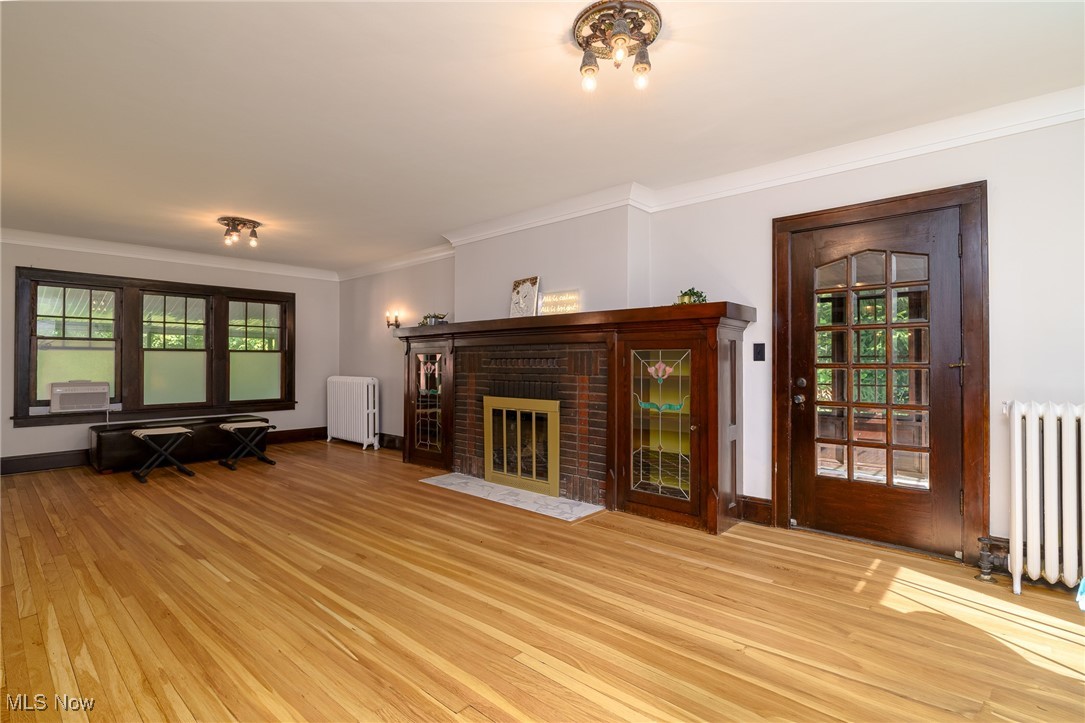 2624 Lee Road Cleveland, OH 44118 - Photo 5 of 50 Unfurnished living room with radiator heating unit, a fireplace, and refinished light
oak hardwood floors with natural hardwood trim and white crown molding