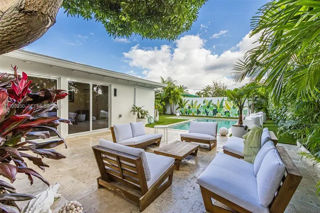 a view of a patio with couches table and chairs and potted plants