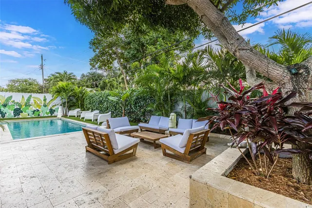 a swimming pool with outdoor seating and plants